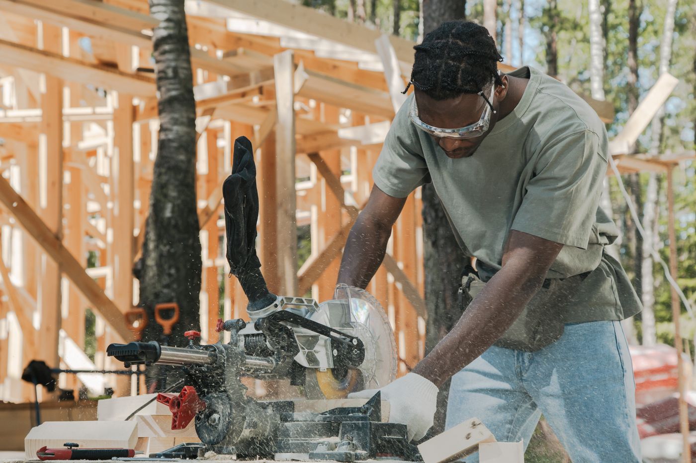 Carpenter cutting timber with a powered saw at a construction site